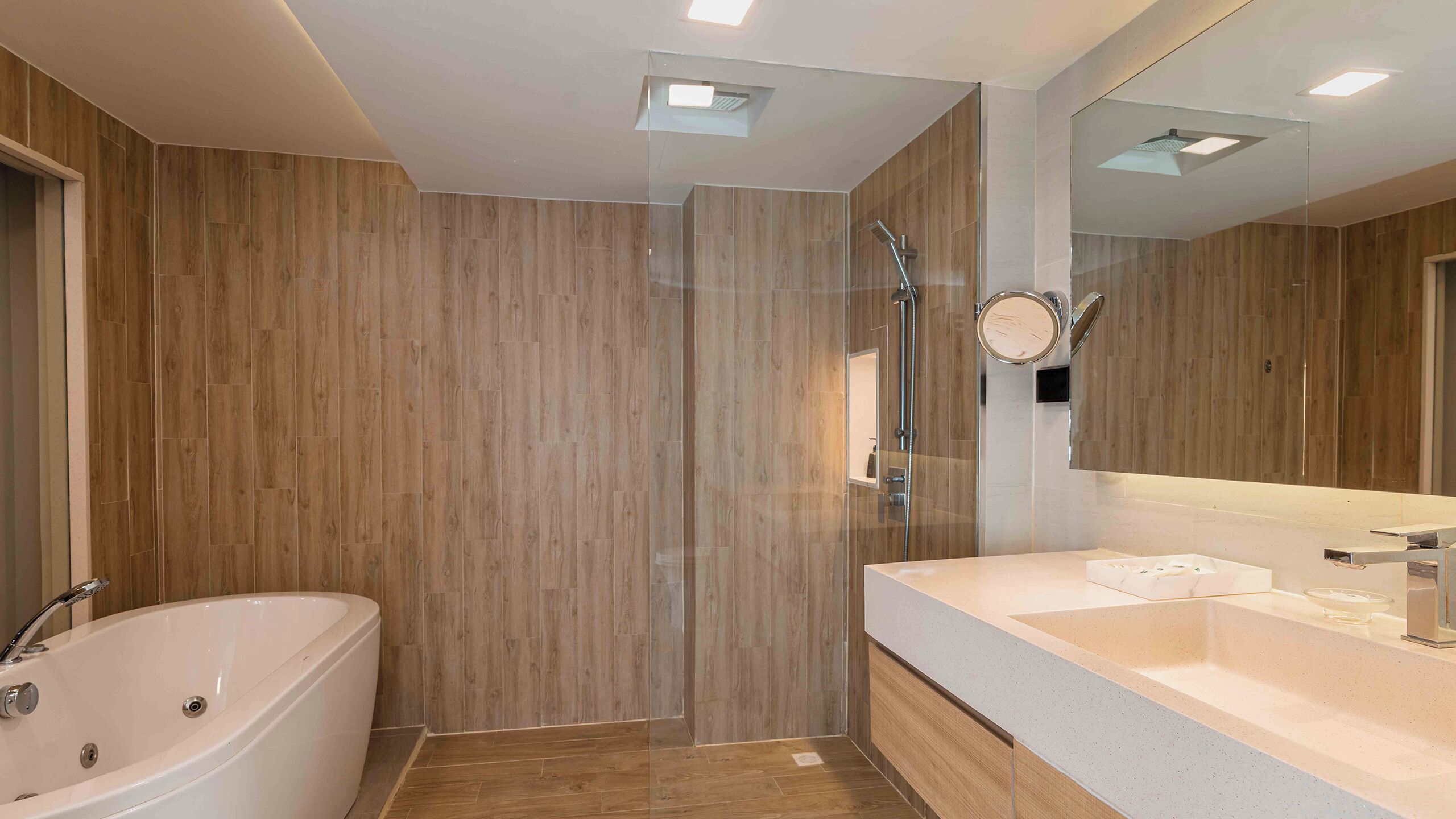 A modern bathroom with a freestanding bathtub, a glass-enclosed shower, and a large mirror above the sink.