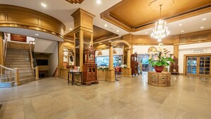 A grand lobby with a staircase, ornate columns, and a chandelier. - City Beach Resort (Hua Hin)