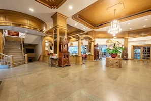 A grand lobby with a staircase, ornate columns, and a chandelier. - City Beach Resort (Hua Hin)
