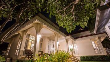 A traditional house with a covered porch, steps leading to the entrance, and a well-maintained garden.