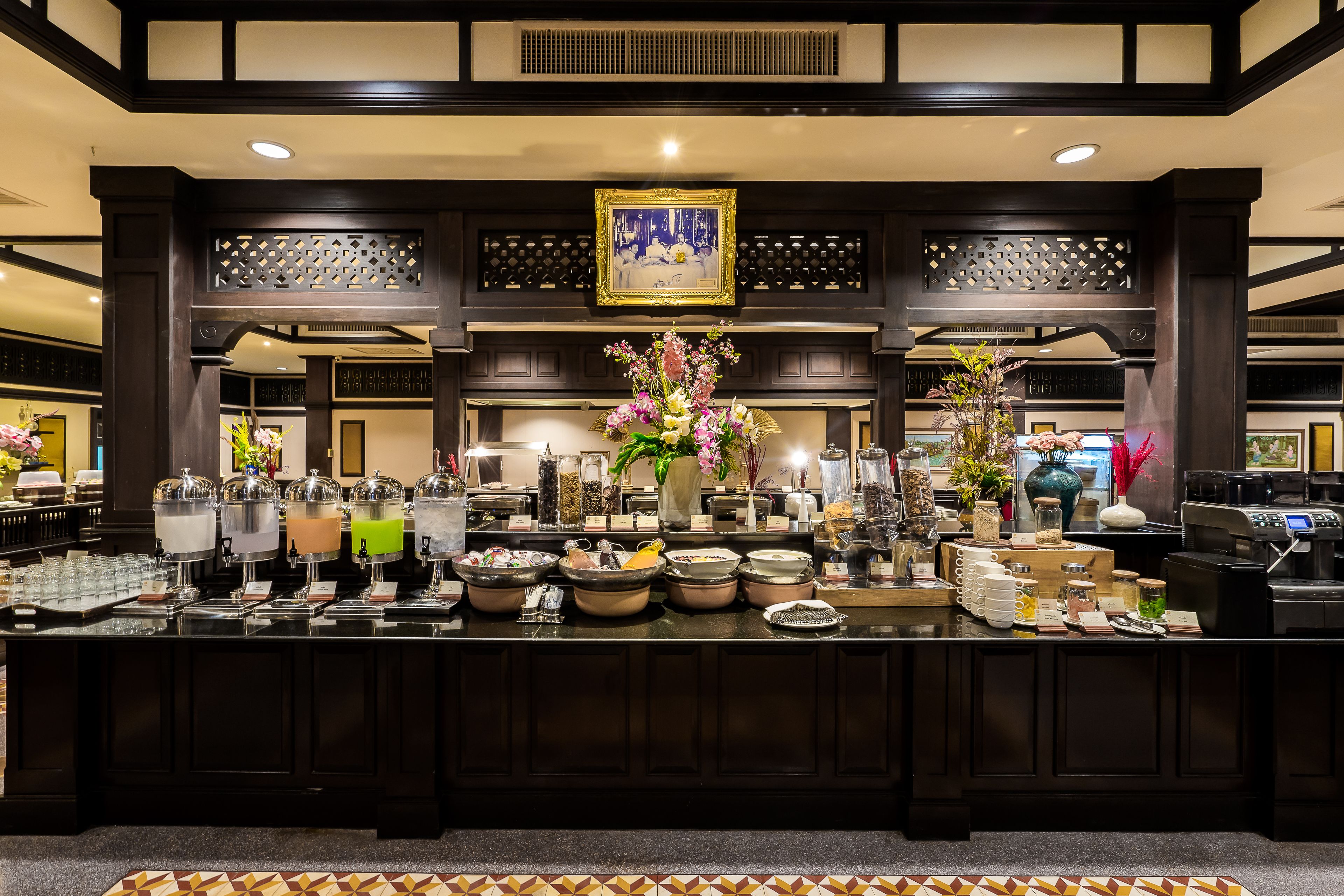 A buffet area with multiple food stations, a decorative centerpiece, and a traditional architectural design.