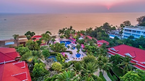 A resort with a swimming pool surrounded by palm trees and red-roofed buildings. - Wora Bura Hua Hin Resort and Spa (Hua Hin)