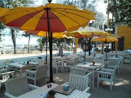 Espace extérieur aménagé avec des tables et des chaises, dont certaines sont dotées de parasols.