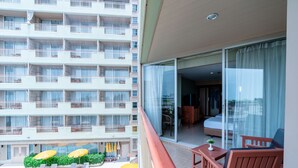A hotel balcony with a pool, lounge chairs, and umbrellas. - Long Beach Cha-Am Hotel (Cha-am)