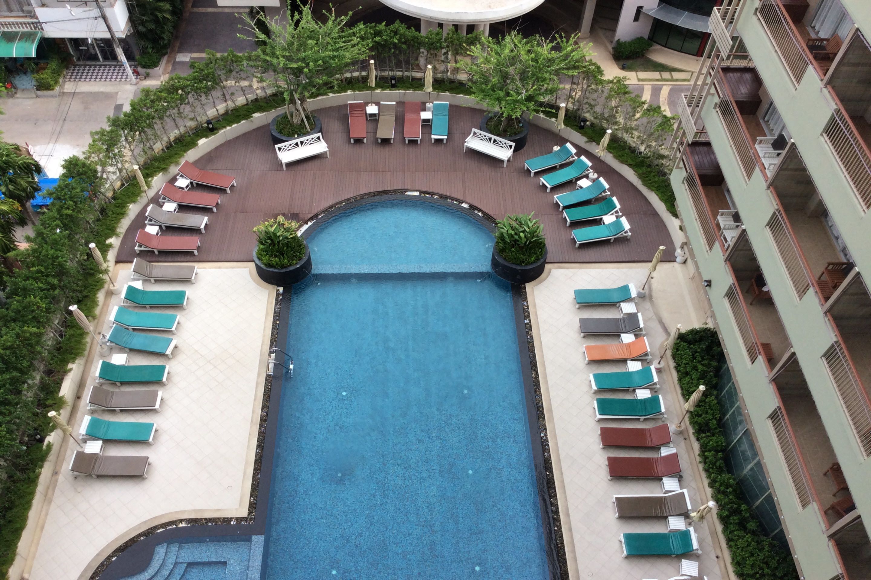A rooftop pool with sun loungers and a circular seating area.