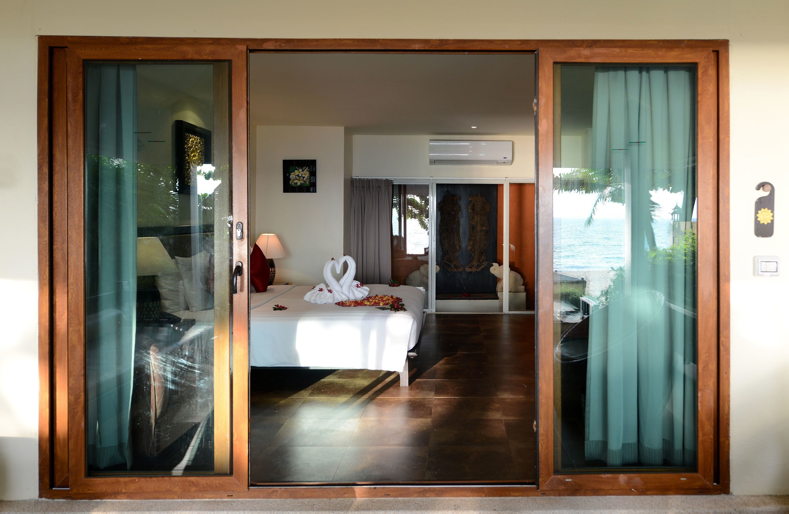 Una habitación de hotel con cama, escritorio y vista al océano.