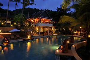 Una piscina al aire libre, sombrillas, tumbonas