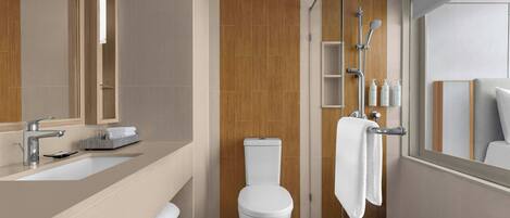 Un baño moderno con un espejo grande, dos lavamanos, un inodoro y una zona de ducha.