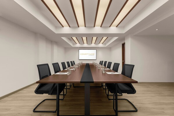 A conference room with a long table, black chairs, and a screen displaying "COURTYARD by Marriott". - Courtyard by Marriott Phuket, Patong Beach Resort (Patong)