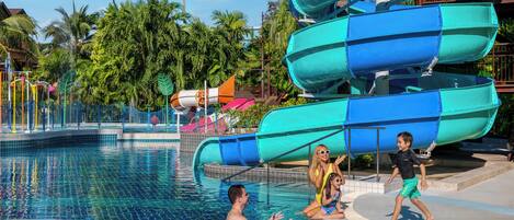 Une piscine avec un toboggan et des palmiers en arrière-plan.