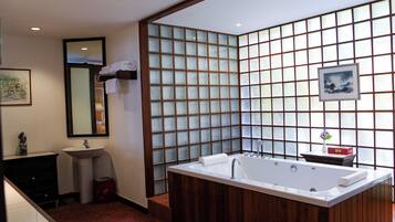 A modern bathroom with a freestanding bathtub, a sink, and a mirror.