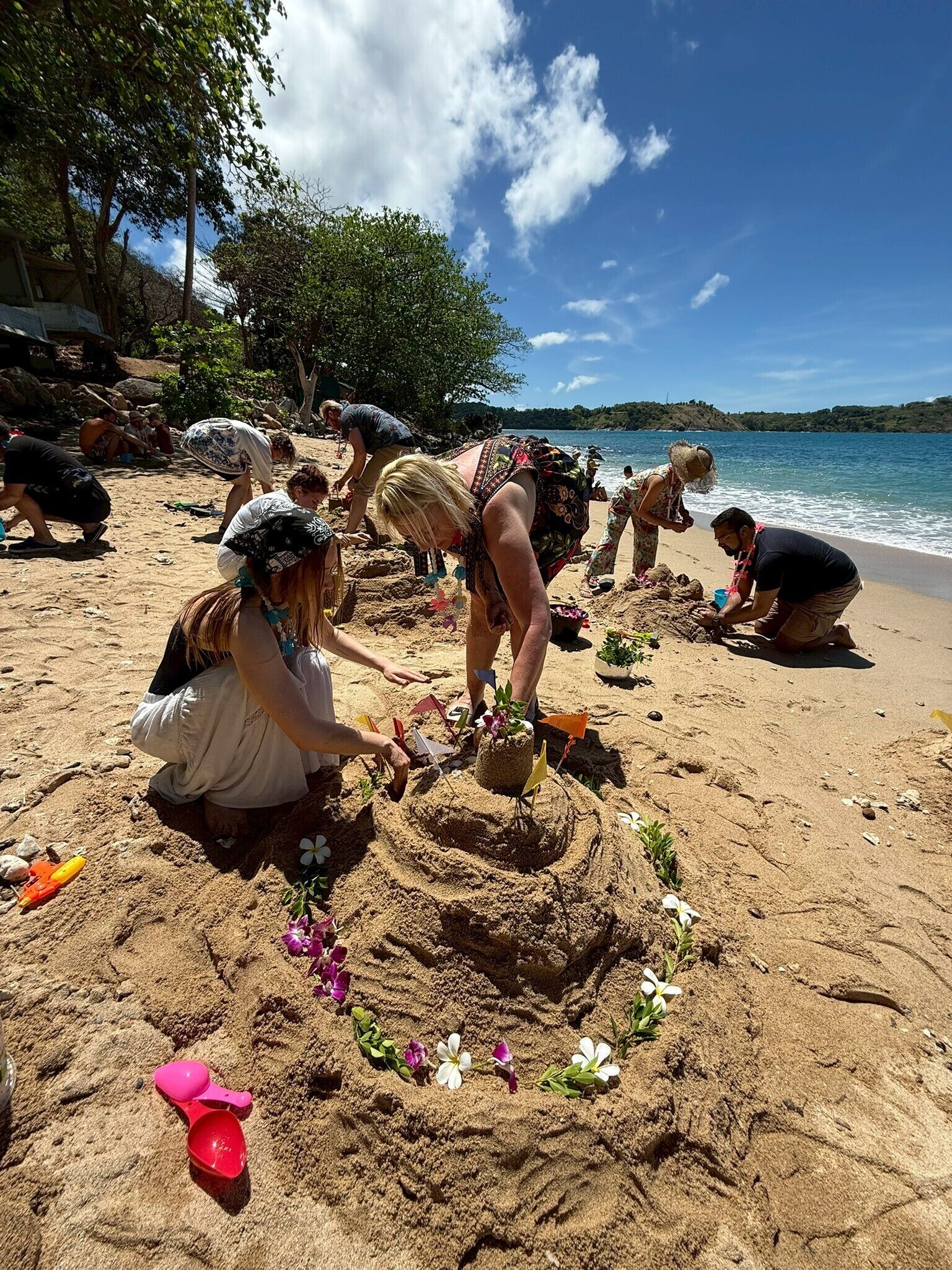 Una playa arenosa con gente practicando esculturas de arena.
