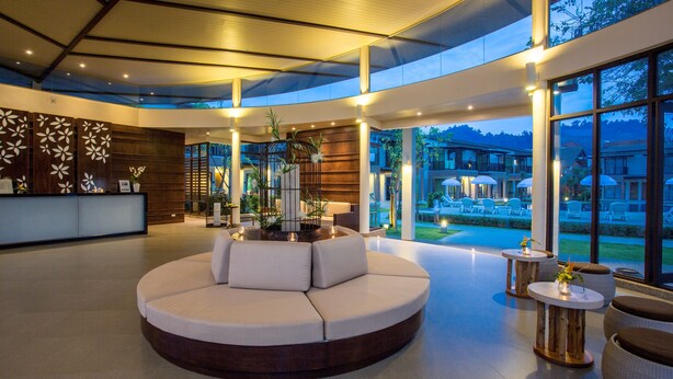 Eine großzügige Lobby mit einer runden Sitzecke, einer Rezeption und großen Fenstern mit Blick auf die umliegende Landschaft.