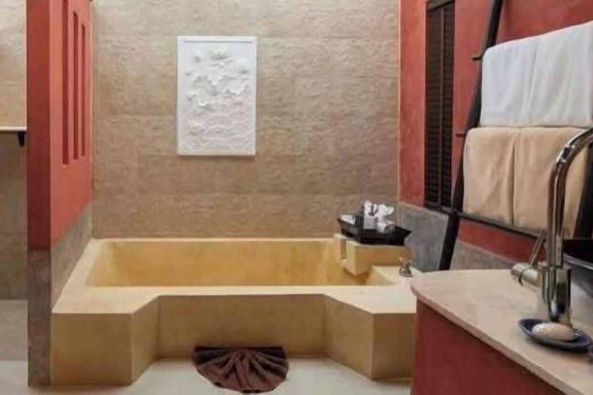 A bathroom with a freestanding bathtub, a towel rack, and a shower area.