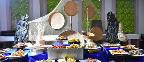A buffet table with various food items and decorative elements.
