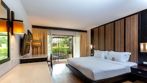 Una habitación de hotel moderna con una cama grande, un escritorio, una silla y vistas al exterior.