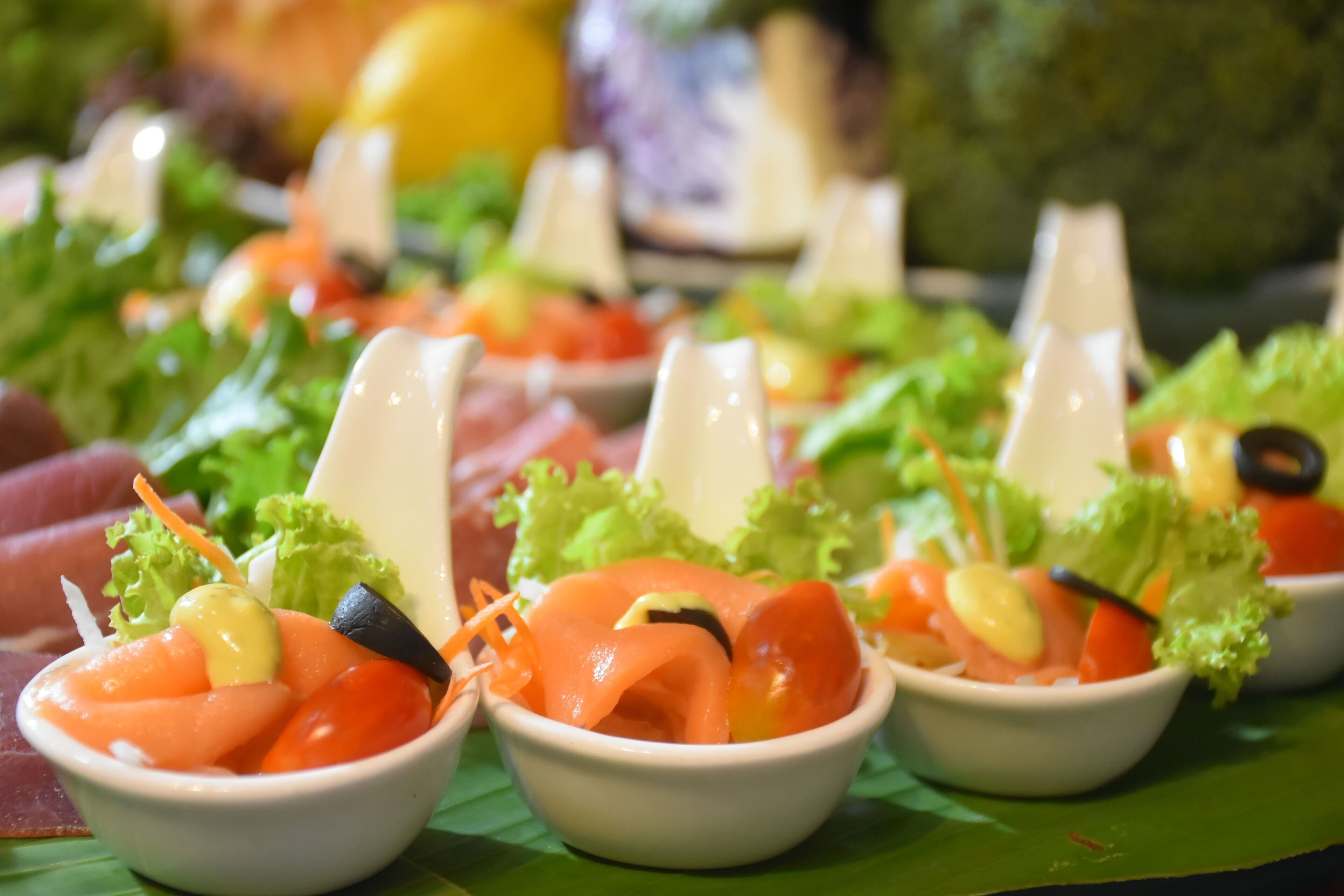 Un bufé con diversos platos, incluyendo salmón y verduras.