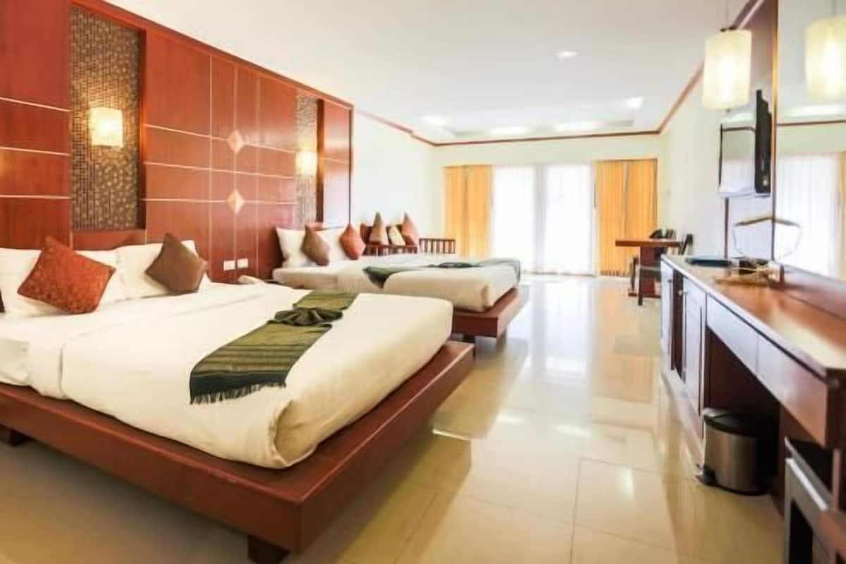 Une chambre d’hôtel avec un grand lit, un bureau et un téléviseur.