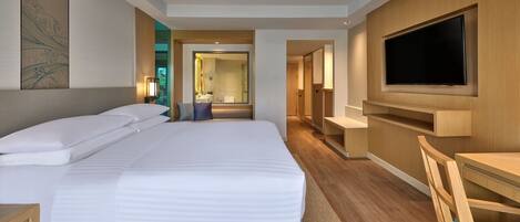 A modern hotel room with a large bed, a TV mounted on the wall, and a desk with a chair.