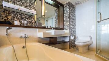 A modern bathroom with a bathtub, a glass shower enclosure, a white sink, and a toilet.