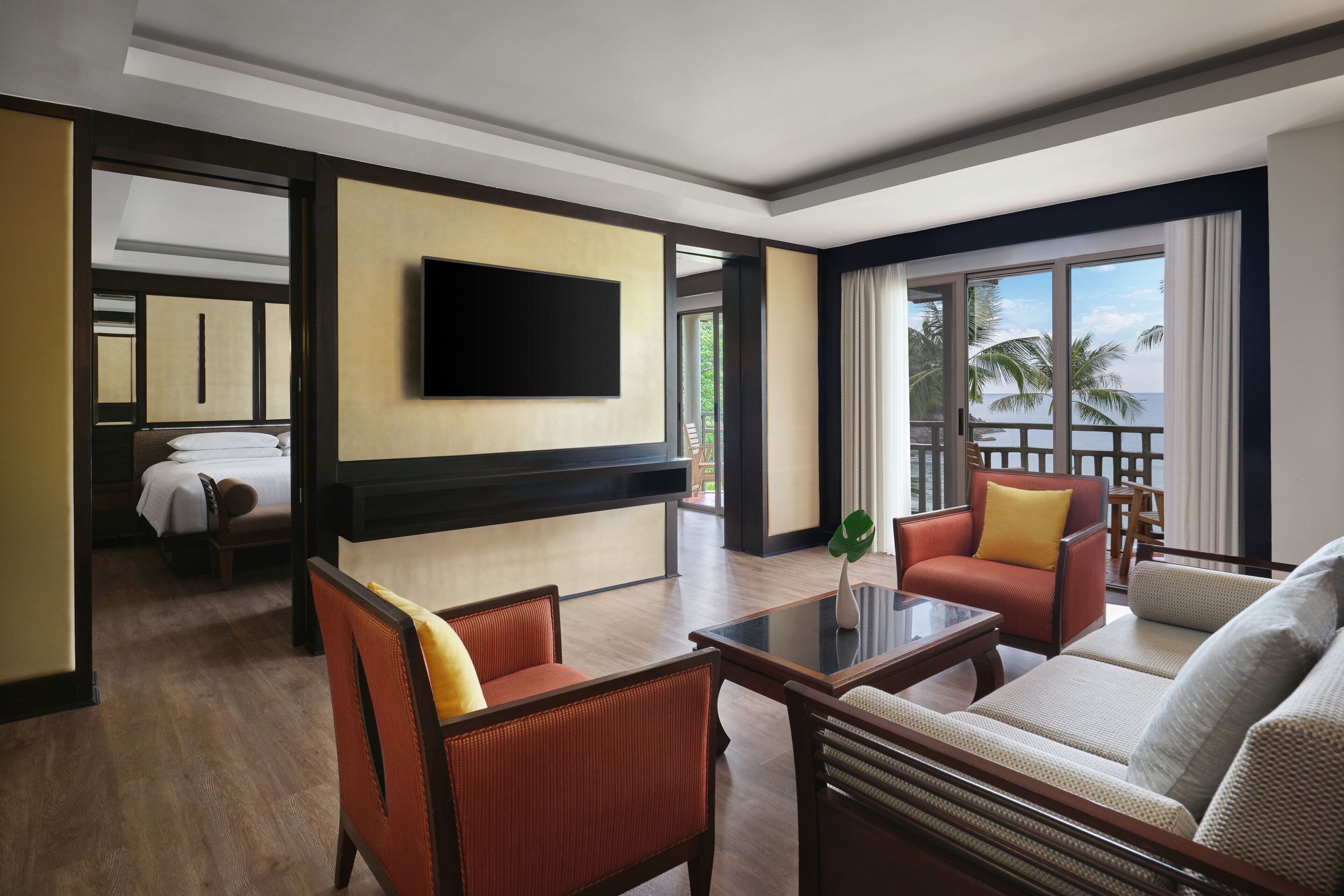 A hotel lobby with a flat-screen TV, seating area, and a view of the outdoors.