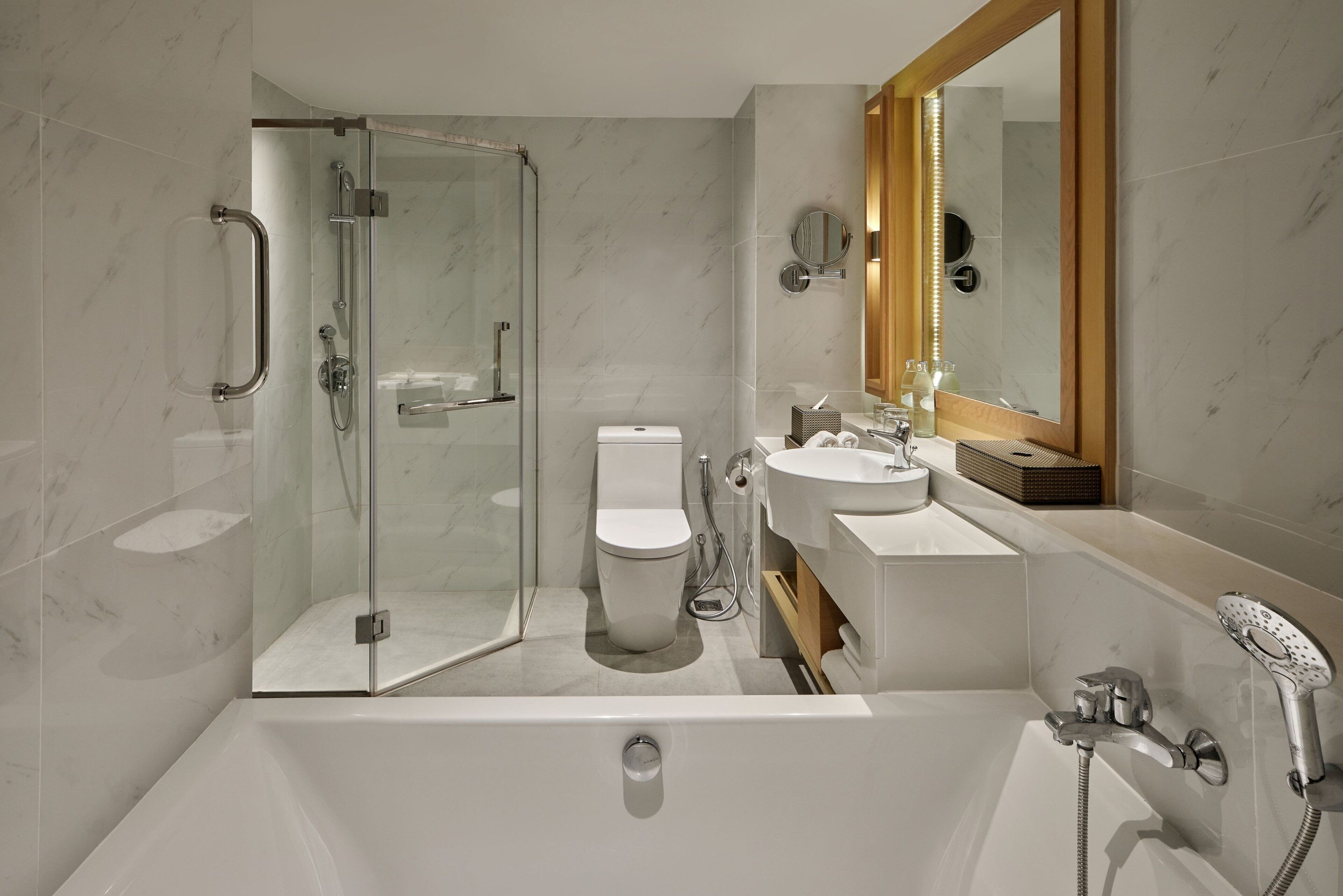 A modern bathroom with a glass-enclosed shower, a toilet, a sink, and a bathtub.