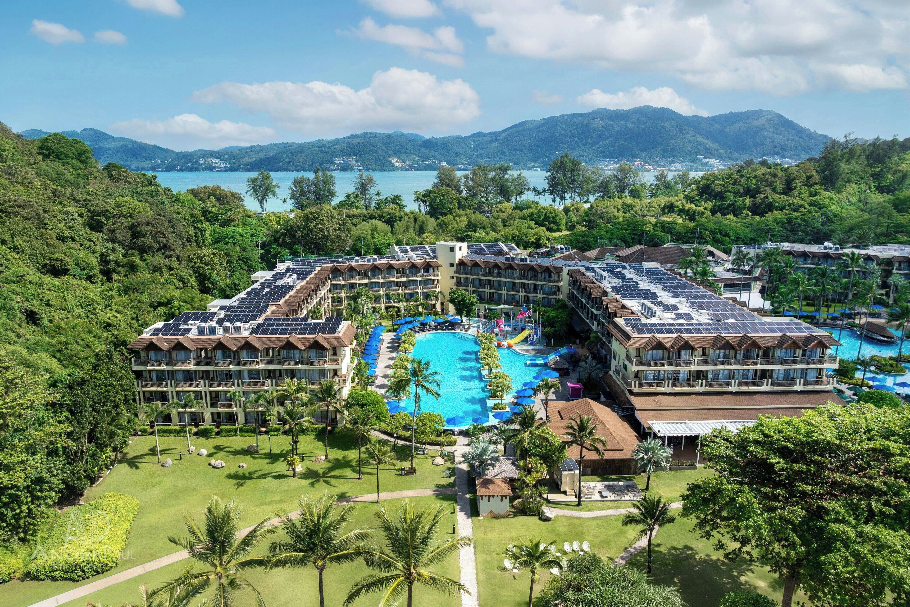 Ein Resort mit mehreren Gebäuden, einem zentral gelegenen Schwimmbad und Solaranlagen auf den Dächern.