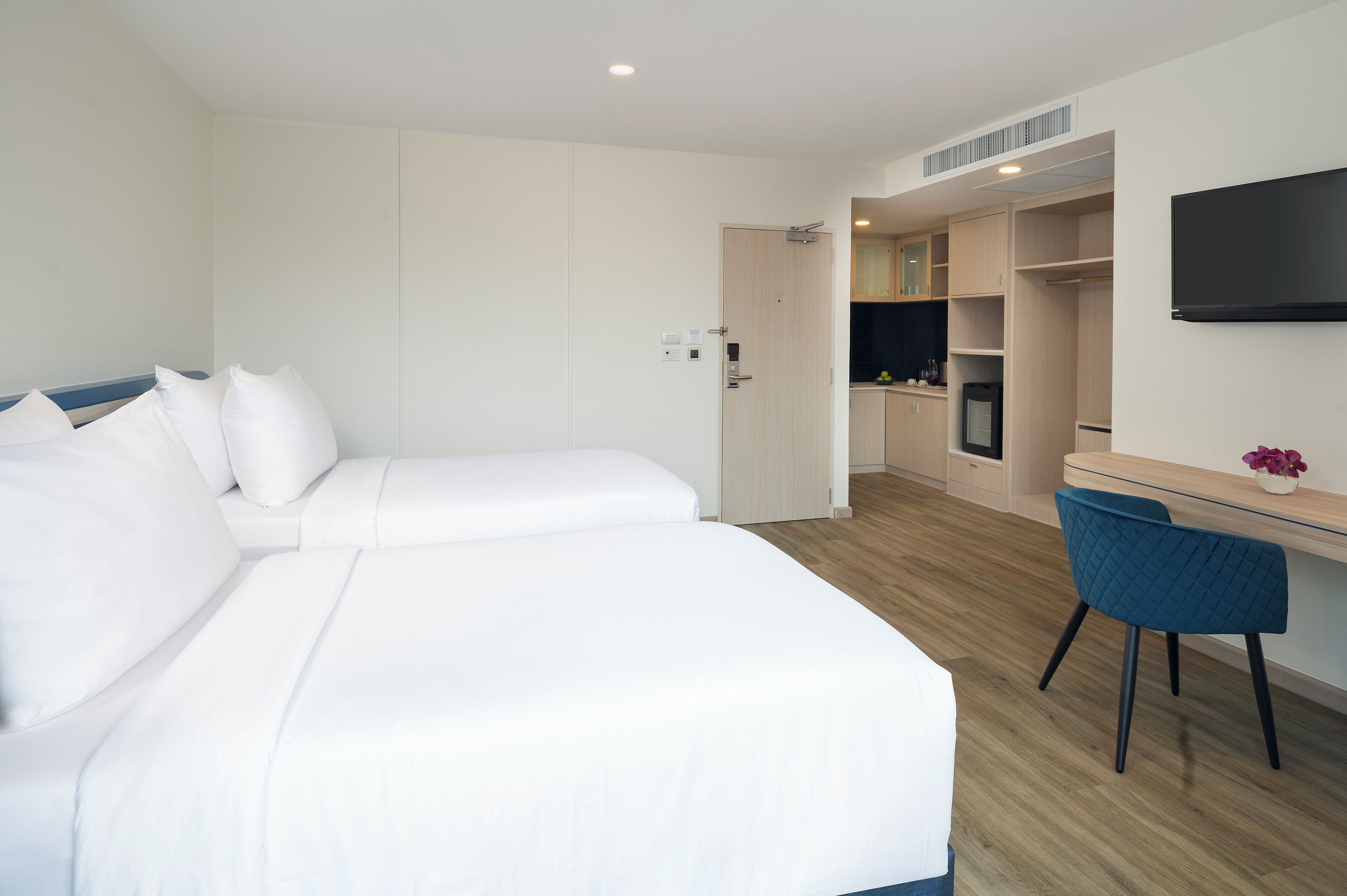 Habitació d'hotel amb un llit gran, un escriptori i un televisor fixat a la paret.
