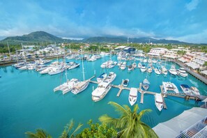 A marina with numerous boats docked, surrounded by buildings and palm trees. - NH Boat Lagoon Phuket Resort (Ko Kaeo)