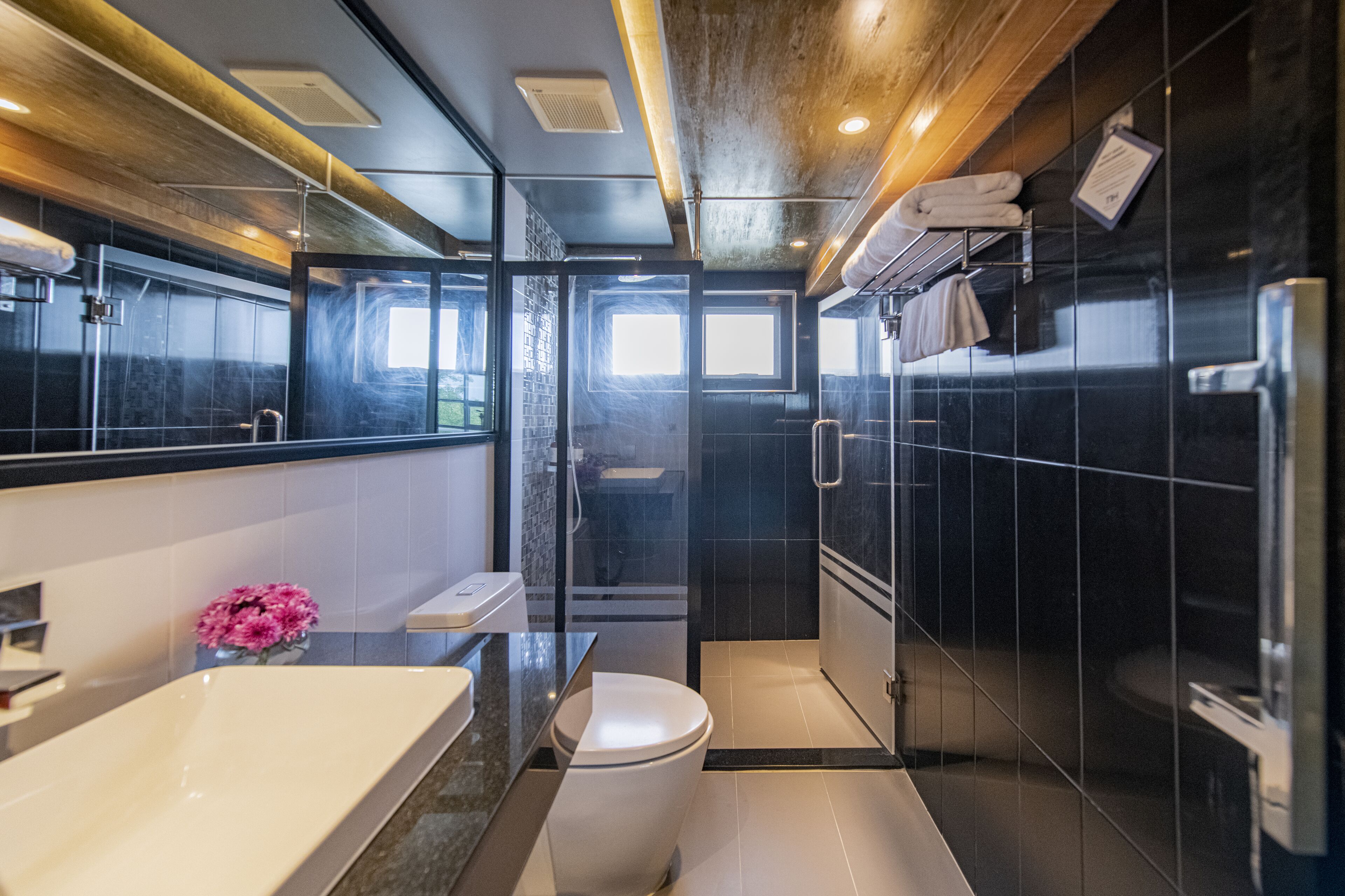 A modern bathroom with a bathtub, toilet, and shower area.