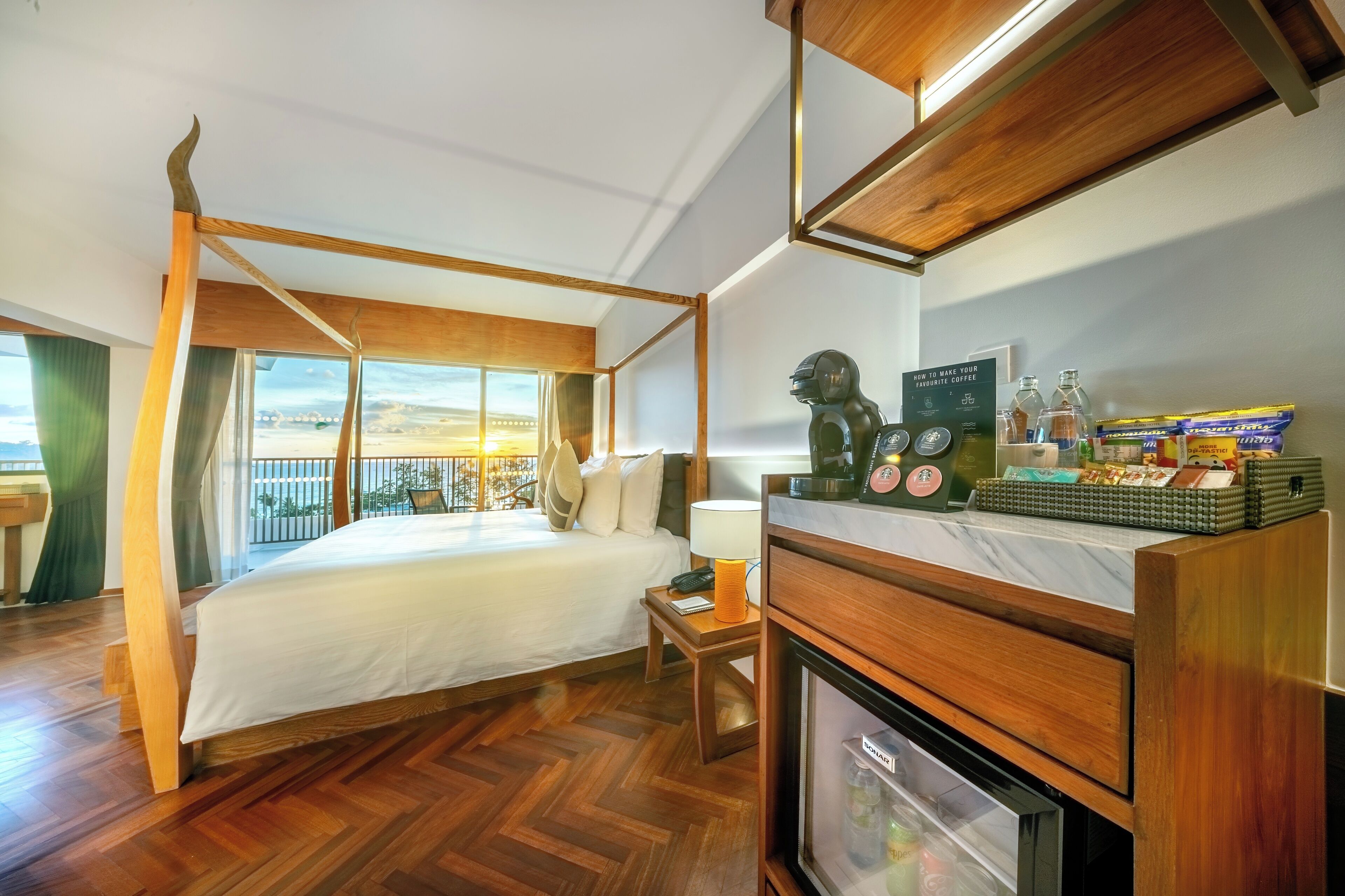 A four-poster bed with a view, a minibar, and a small table with a lamp.
