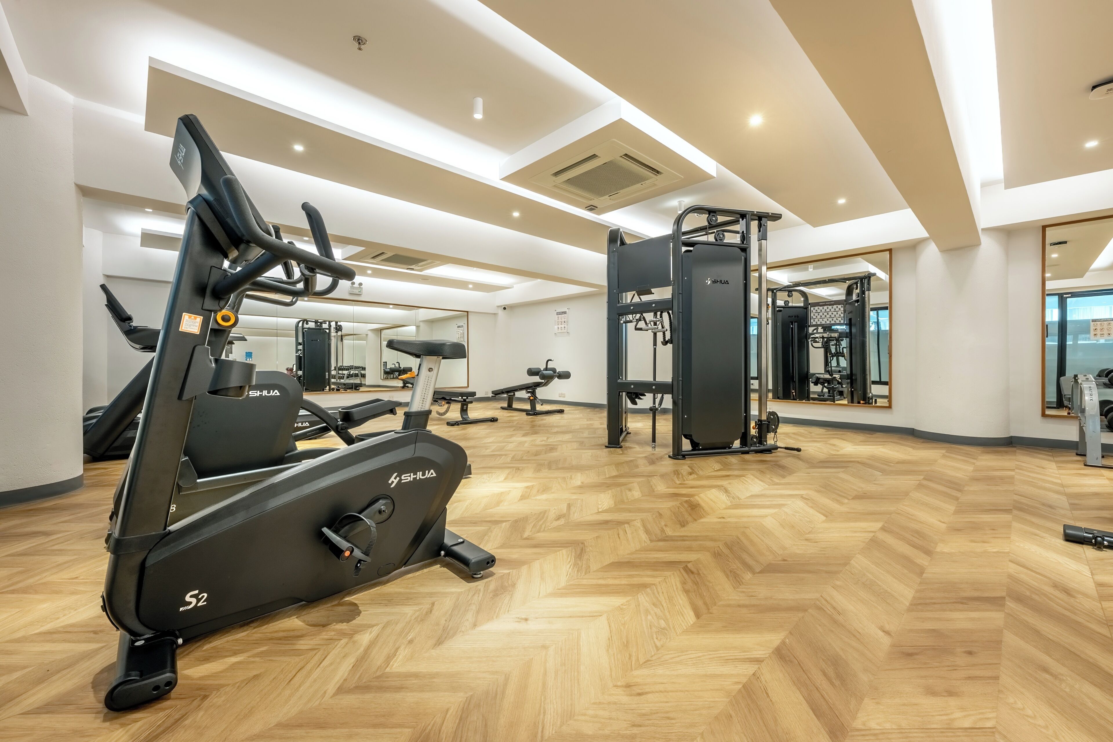 A gym with cardio machines, weightlifting equipment, and mirrors.