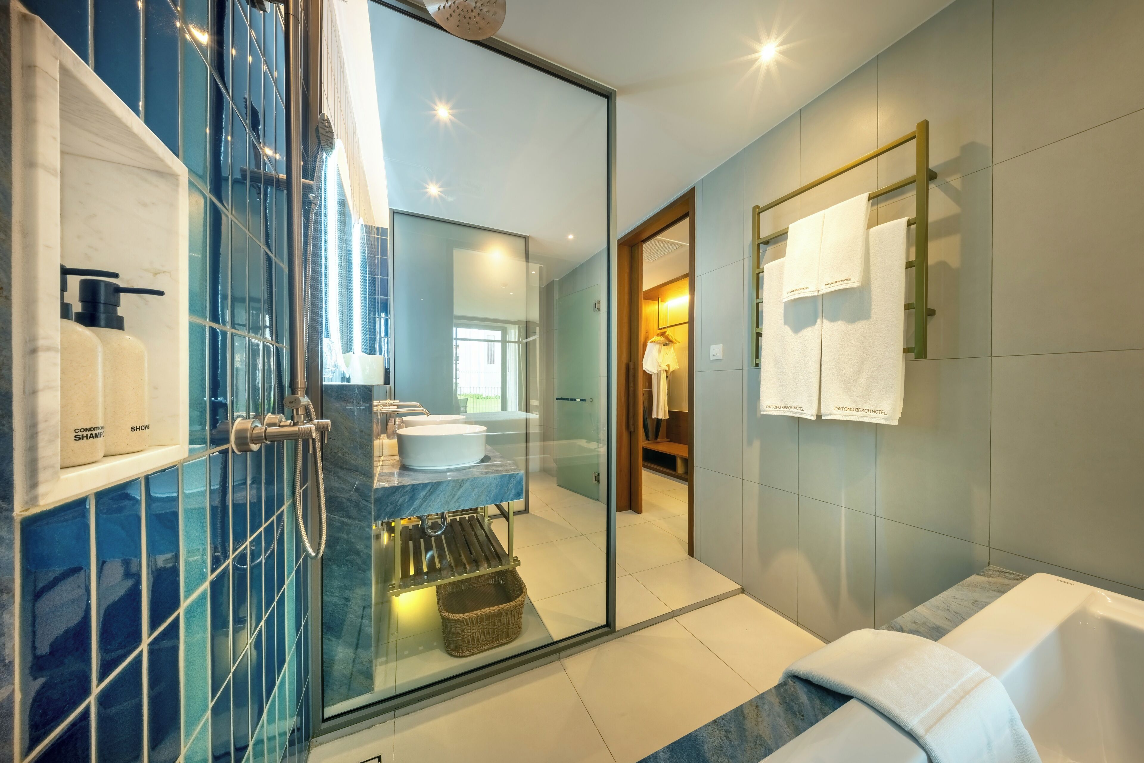 Un baño moderno con cabina de ducha de vidrio, bañera y tocador con lavabo y espejo.