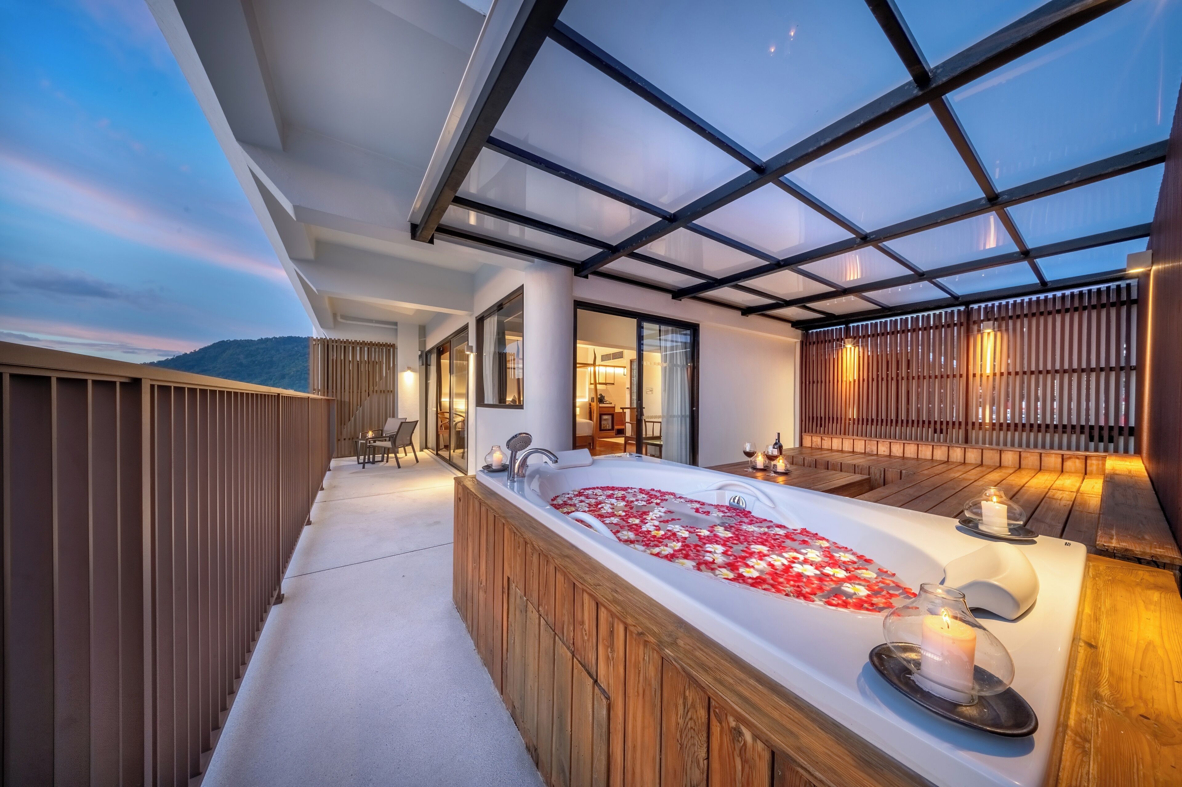A modern outdoor spa area with a hot tub, wooden deck, and a glass ceiling.