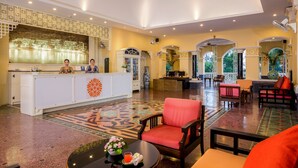 A spacious lobby with a reception desk, seating areas, and a decorative floor pattern. - The Front Village (Karon)