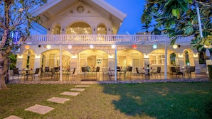 A large, elegant building with a balcony and multiple dining areas. - The Front Village (Karon)