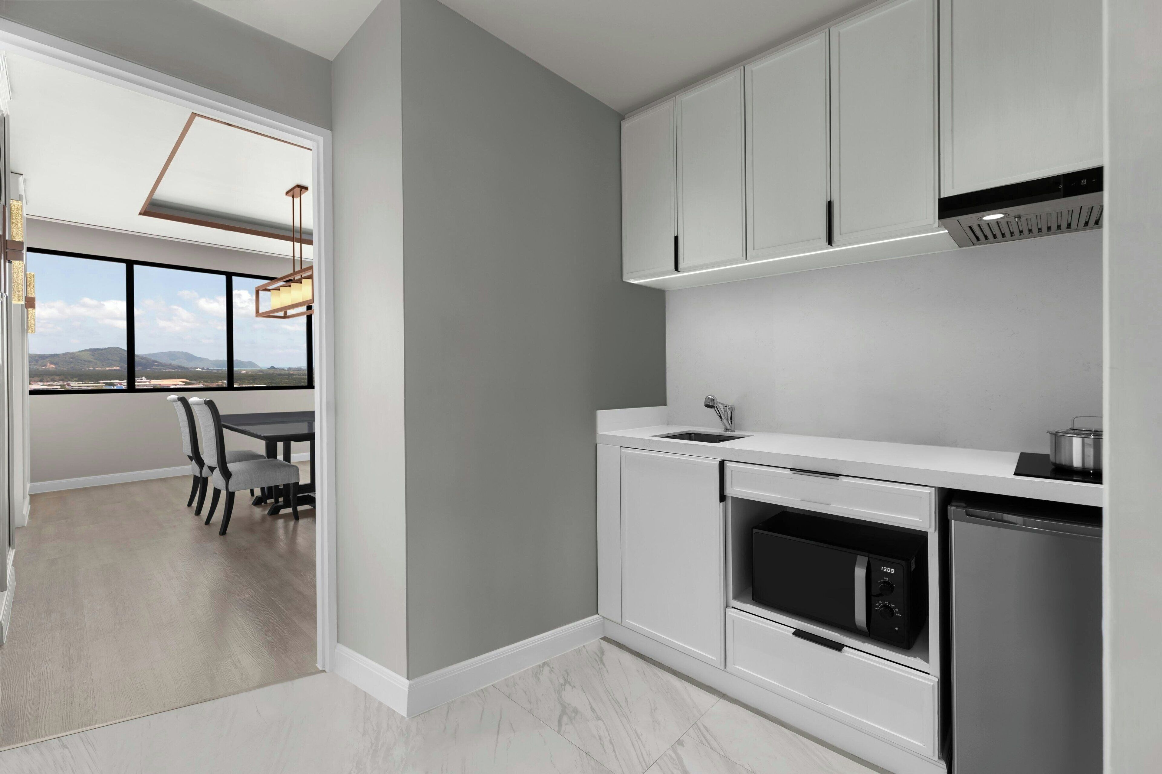 A modern kitchen with white cabinets, a built-in oven, and a dishwasher.