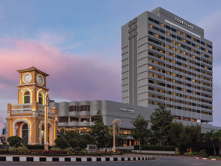 A hotel with a clock tower and a modern building with the name 'Courtyard' on it.