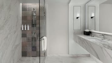 A modern bathroom with a shower area featuring patterned tiles, a glass-enclosed shower, a marble-topped sink, and a large mirror.