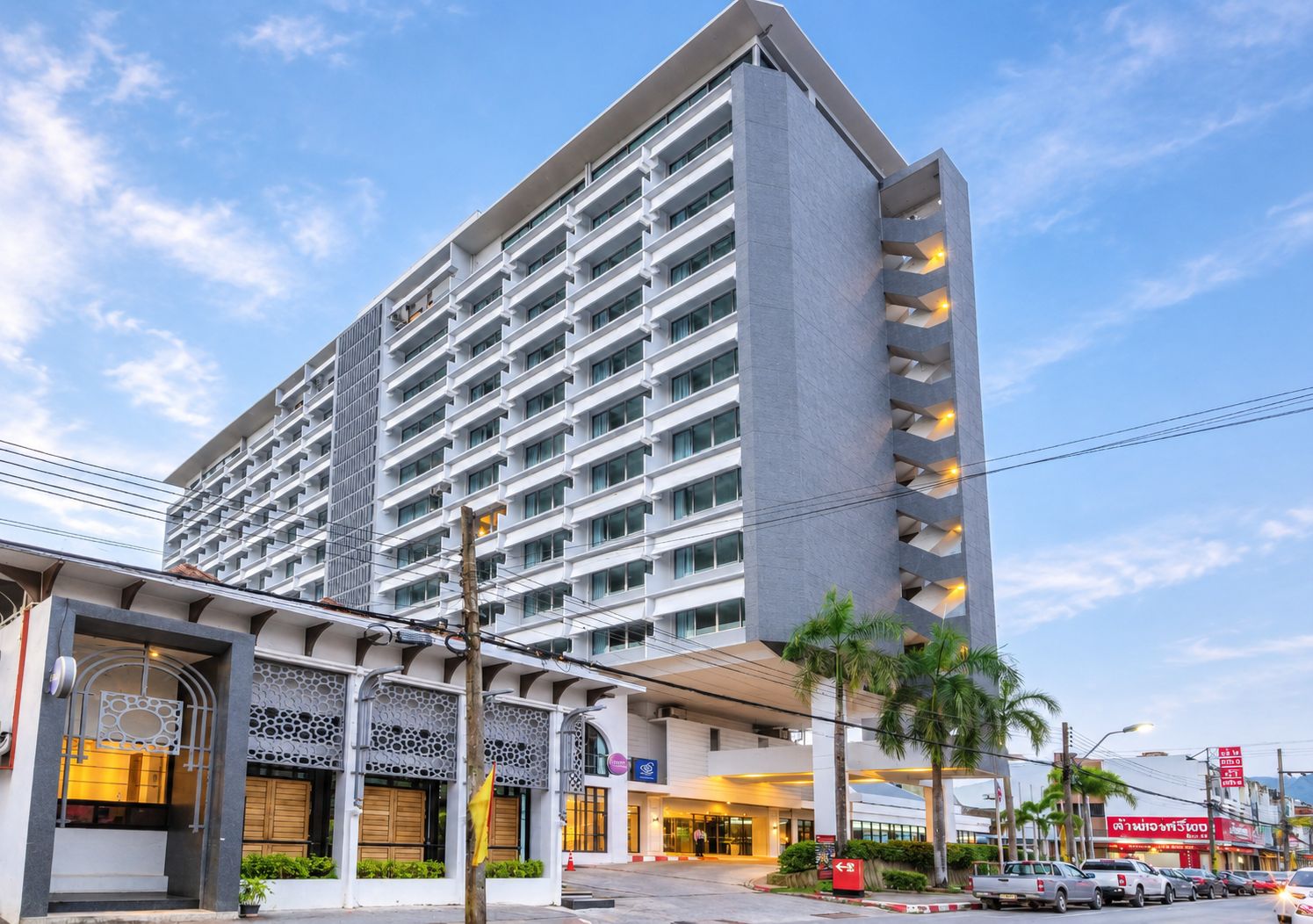 Ein mehrstöckiges Hotel mit moderner Fassade, Balkonen und einem Eingangsbereich mit dekorativen Elementen.