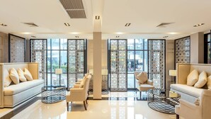 A modern hotel lobby with two sofas, a coffee table, and decorative screens. - Pearl Hotel Phuket (Phuket)