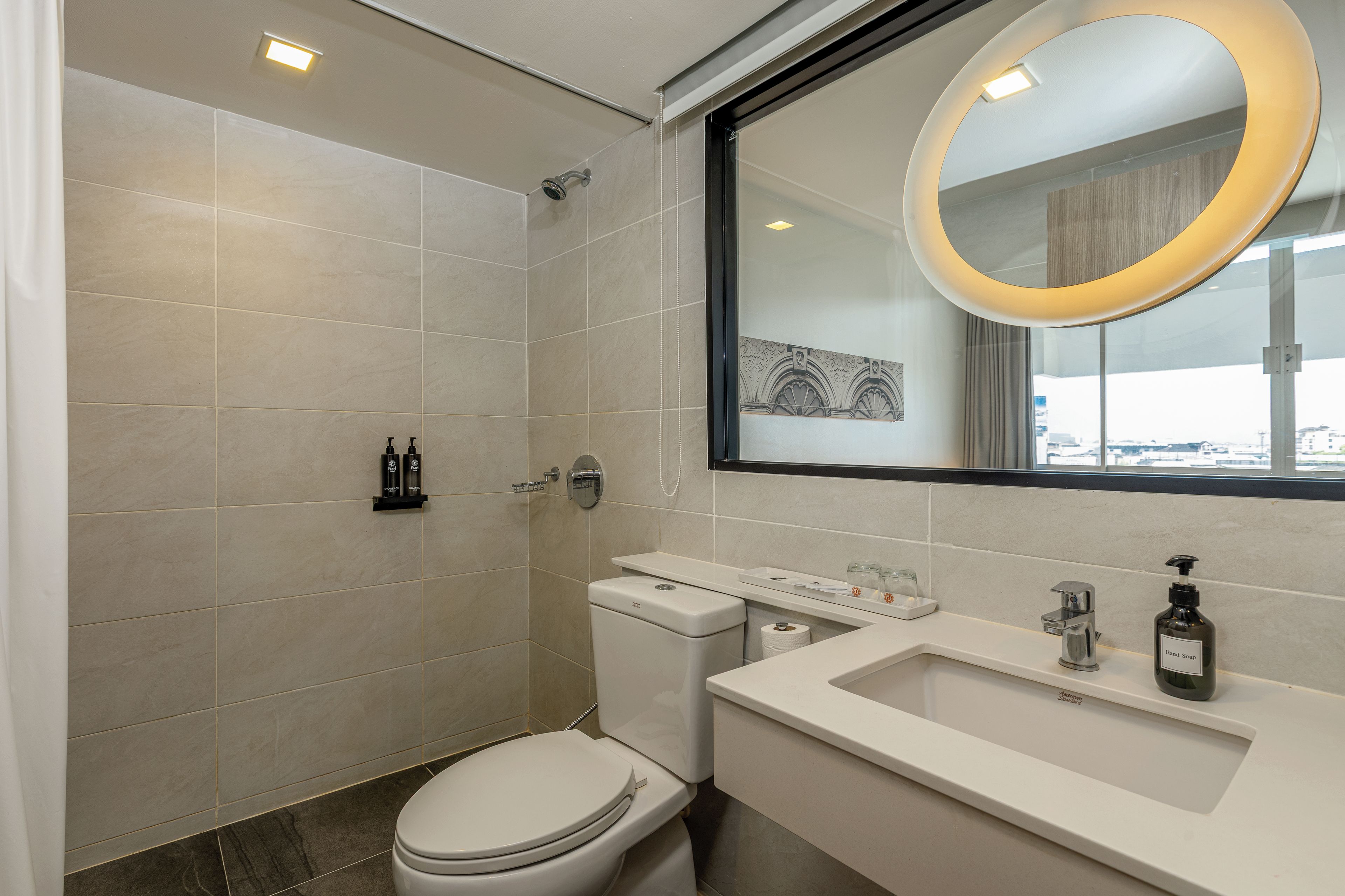 A modern bathroom with a toilet, sink, and shower.