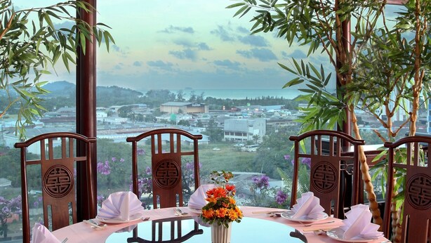 A table set for four with a view of a cityscape. - Pearl Hotel Phuket (Phuket)