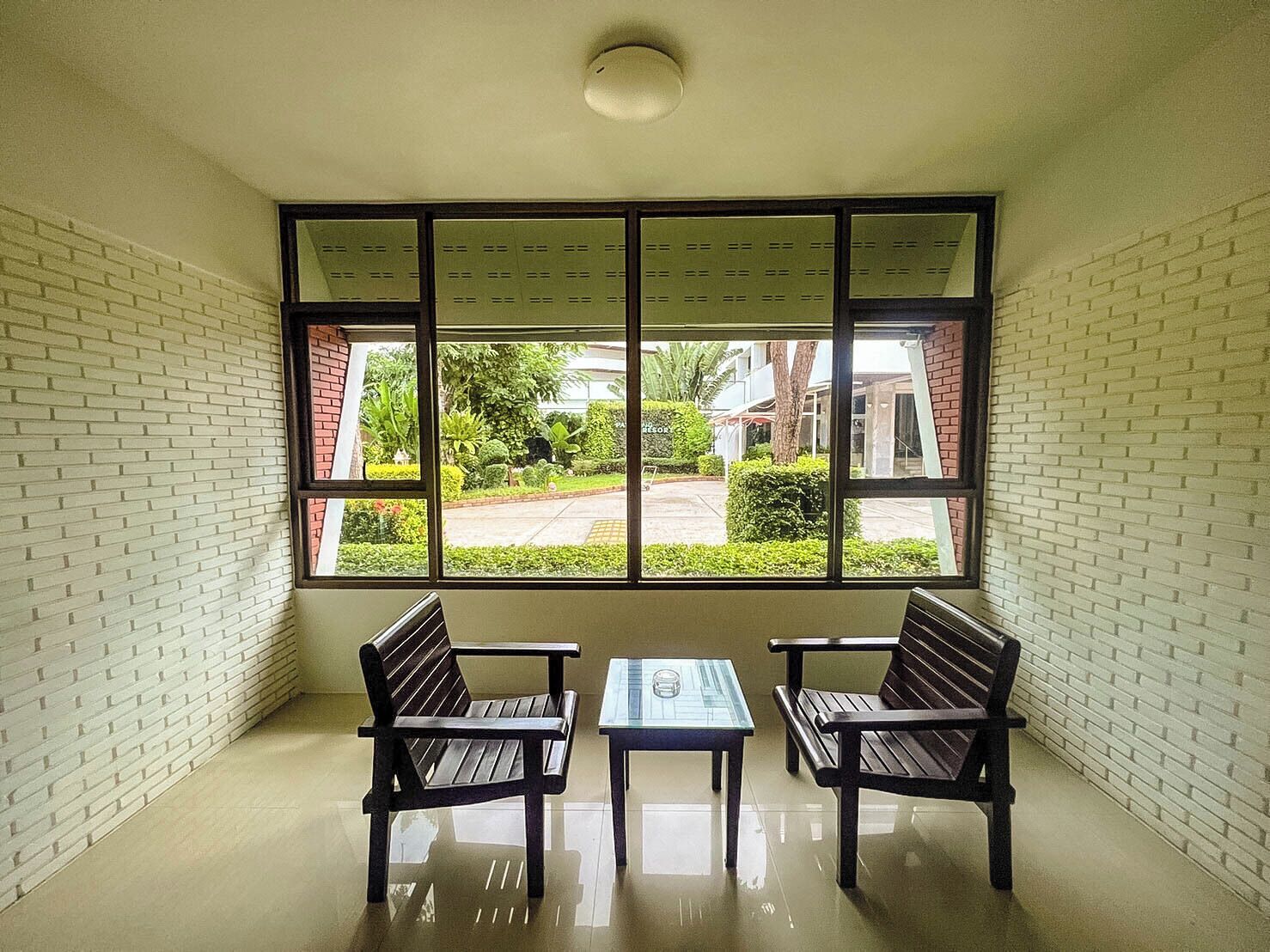 A room with a large window, two wooden benches, and a small table.