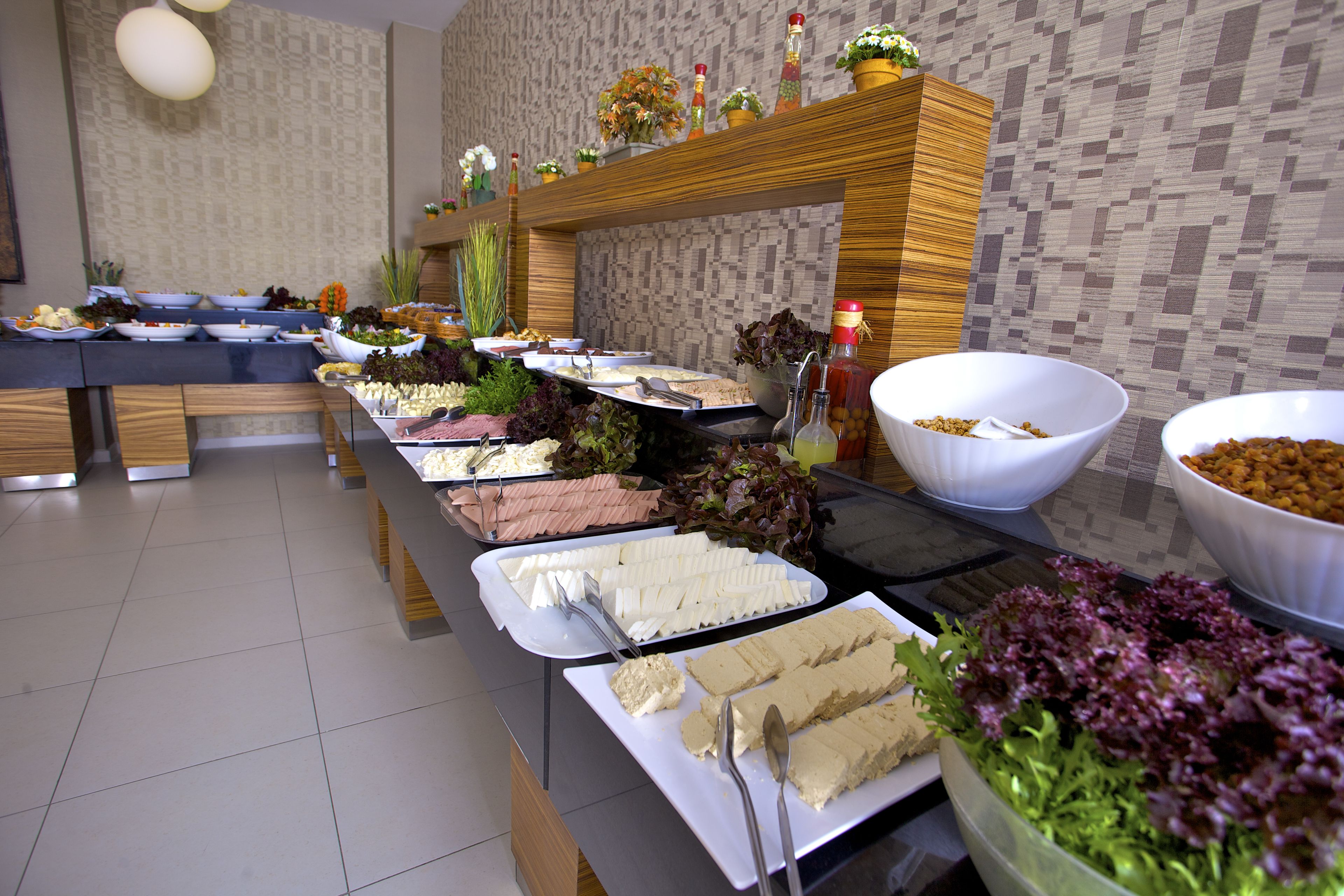 A buffet setup with various food items and utensils.