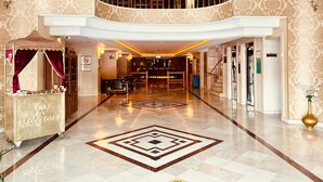 A grand hotel lobby with a high ceiling, a central seating area, a reception desk, and a staircase leading to an upper level. - Askoc Hotel ve Spa (Istanbul)