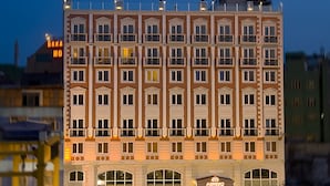 A multi-story hotel with a symmetrical facade, large windows, and a central entrance with a sign. - Askoc Hotel ve Spa (Istanbul)