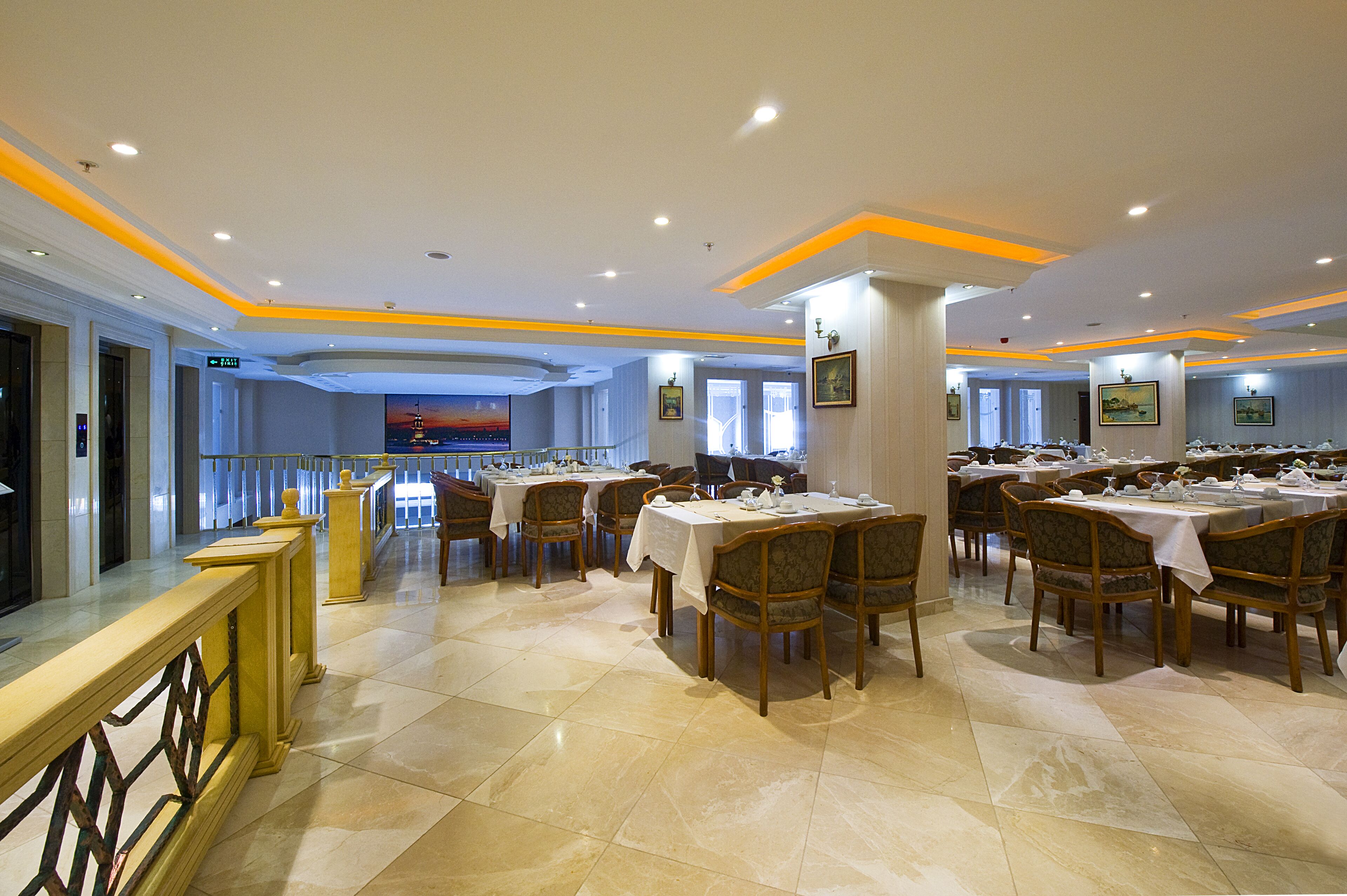 A spacious dining area with multiple tables and chairs, a marble floor, and a view of a cityscape through large windows.