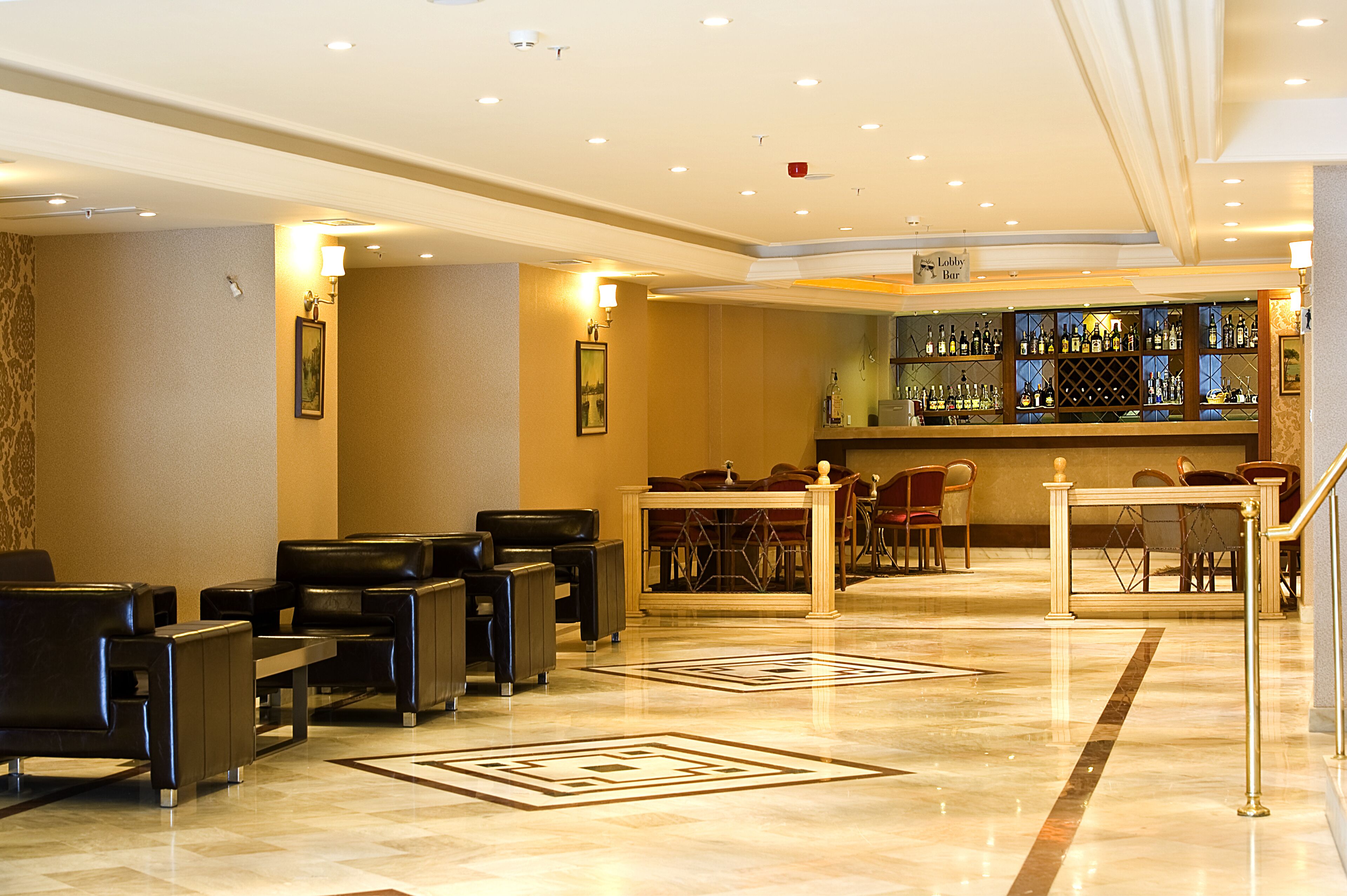 Un vestíbulo con asientos, una zona de bar y un mostrador de recepción.