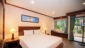 Camera d'albergo con un letto grande, due comodini con lampade, un tavolino e una finestra con tende, oltre a un quadro appeso al muro.